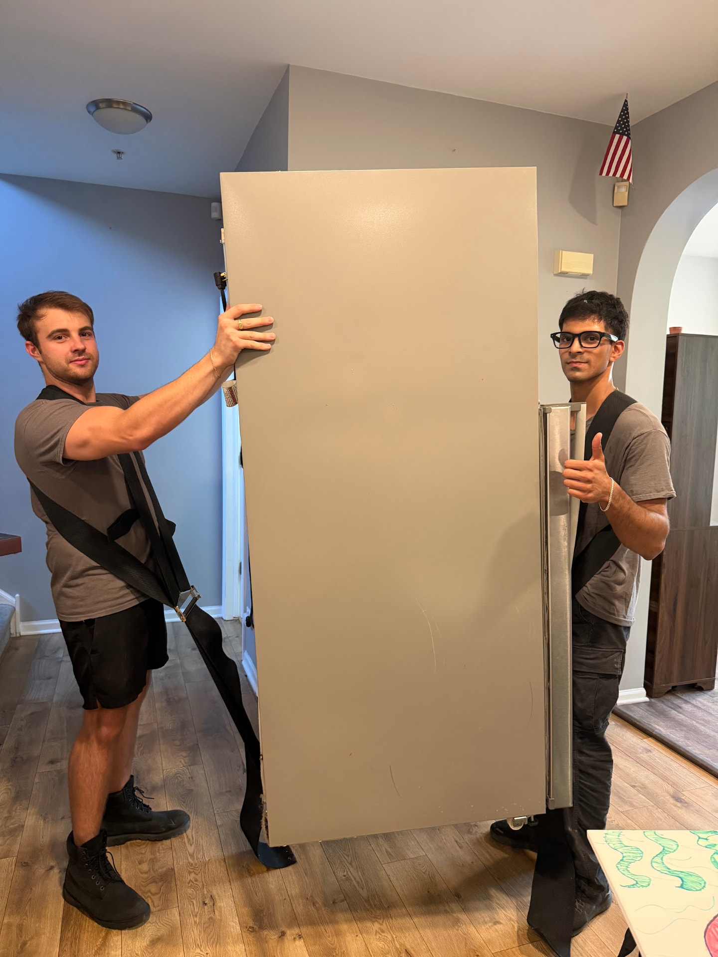 Two Chicago Loaders movers carefully moving a tall cabinet inside a home